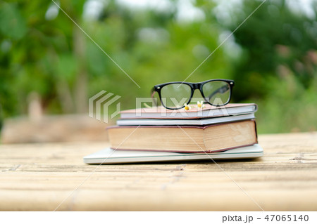 Books and eyeglasses with nature background. Books and eyeglasses with nature background. 47065140