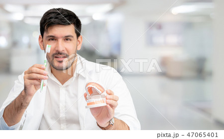 Dentist with toothbrush, focus at toothbrush. 47065401