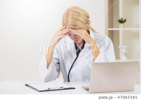 Serious doctor working in hospital office. 47065565