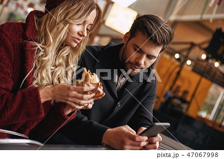 Young couple are making selfie. Holding sandwiches at the street food market. Young couple are making selfie. Holding sandwiches at the street food market. 47067998