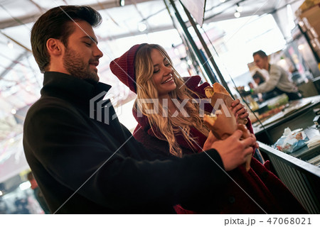Young couple are buying sandwiches at sandwich bar Young couple are buying sandwiches at sandwich bar 47068021