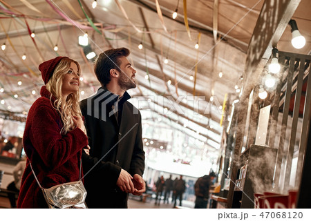 Happy young couple walking around street food market. Blurred people at photo 47068120