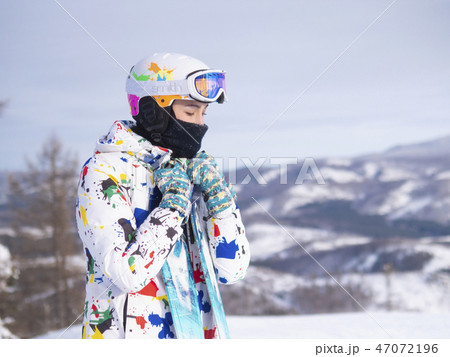 girl holding skis in her hands Happy girl holding skis and ski poles in hands, sitting in snow girl holding skis in her hands Happy girl holding skis and ski poles in hands, sitting in snow 47072196