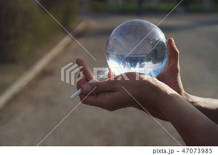 Contact juggling. Hand, acrylic ball and cigarette 47073985