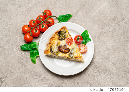 Slice of traditonal homemade spinach chicken quiche tart or pie on plate 47075164