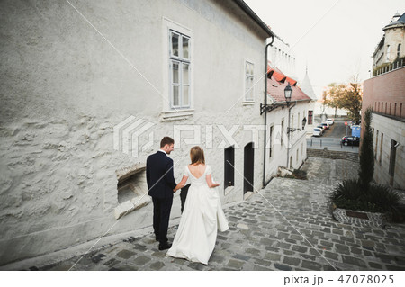 Gorgeous wedding couple walking in the old city Gorgeous wedding couple walking in the old city 47078025