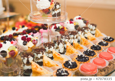 Delicious sweets on wedding candy buffet with desserts, cupcakes Delicious sweets on wedding candy buffet with desserts, cupcakes 47078335