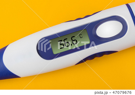 Electronic medical thermometer (36.6) on yellow 47079676
