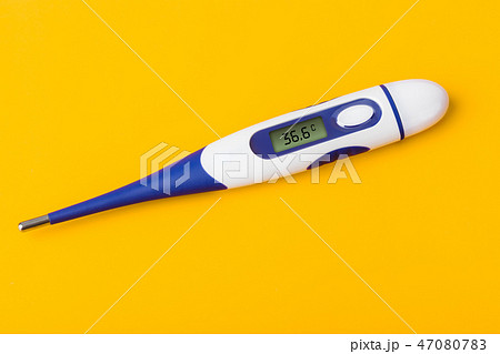 Electronic medical thermometer (36.6) on yellow 47080783