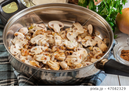Mushrooms and onion on a fried pan 47082329
