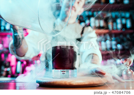 Expert barman is making cocktail at night club. 47084706