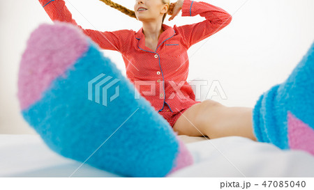 Woman in pajamas wearing furry warm socks 47085040