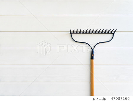 Rake hanging on white wooden texture wall 47087166