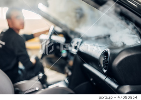 Carwash, worker cleans salon with steam cleaner Carwash, worker cleans salon with steam cleaner 47090854
