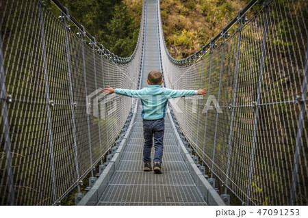kid on suspended bridge 47091253