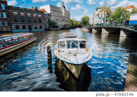 View on the bridge through the river channel with boat in front, typical picture of canals in 47092546