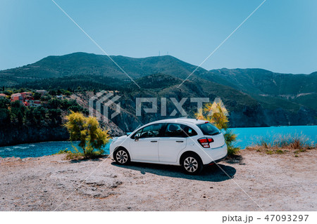 Vacation travel with car concept. Rental hired car in front of amazing bay with turquoise water Vacation travel with car concept. Rental hired car in front of amazing bay with turquoise water 47093297