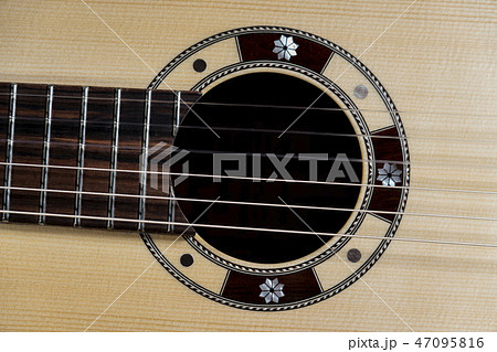 Closeup of rosette sound hole of an acoustic guitar 47095816