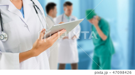 Doctor working in hospital with other doctors. Doctor working in hospital with other doctors. 47098426