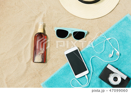 smartphone, camera, towel, hat and shades on beach 47099060