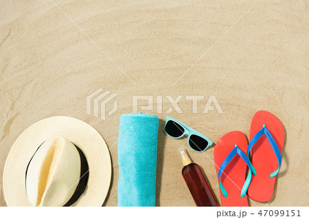 straw hat, flip flops and sunglasses on beach sand straw hat, flip flops and sunglasses on beach sand 47099151