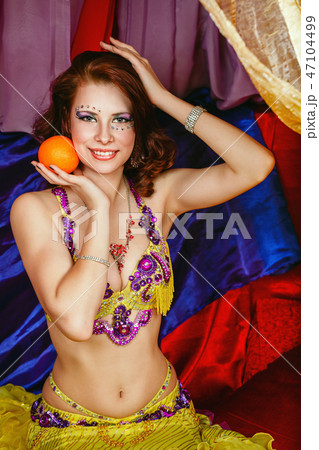 Oriental beauty is holding an orange 47104499