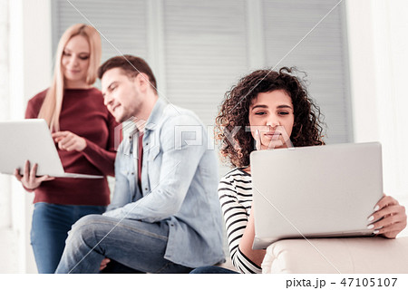 Smart young woman looking at the laptop screen Smart young woman looking at the laptop screen 47105107