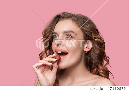 beauty portrait of a cute girl in act to eat a chocolate candy beauty portrait of a cute girl in act to eat a chocolate candy 47110876