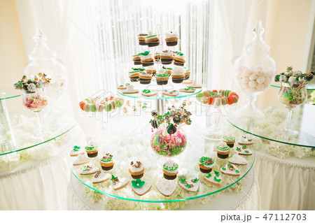 Delicious and tasty dessert table with cupcakes shots at reception closeup Delicious and tasty dessert table with cupcakes shots at reception closeup 47112703