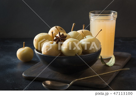 Pickled apples in bowl and apple sidr on dark. 47113100