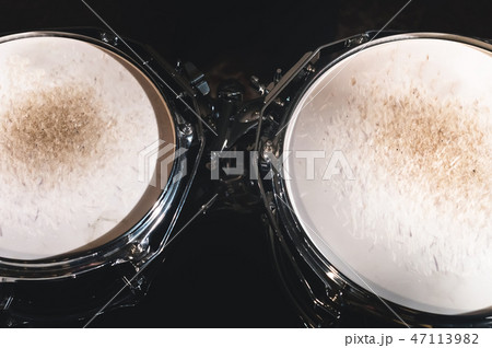 Closeup view of a drum set in a dark studio. Black drum barrels with chrome trim. The concept of Closeup view of a drum set in a dark studio. Black drum barrels with chrome trim. The concept of 47113982