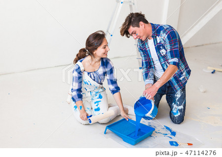 People, redecoration and renovation concept - Horizontal portrait of couple pour paint 47114276