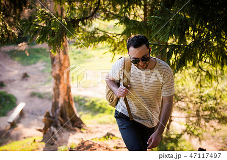 Man using hiking with backpack outdoors in woods 47117497