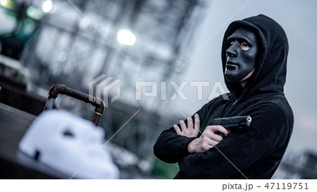 Mystery man in black mask holding gun Mystery man in black mask holding gun 47119751