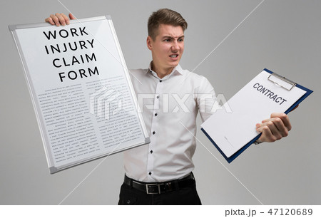 young man holding a form with a claim of injury at work and blank contract form isolated on a light 47120689