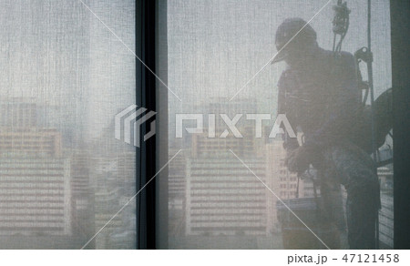 Silhouette images of man cleaning window building 47121458
