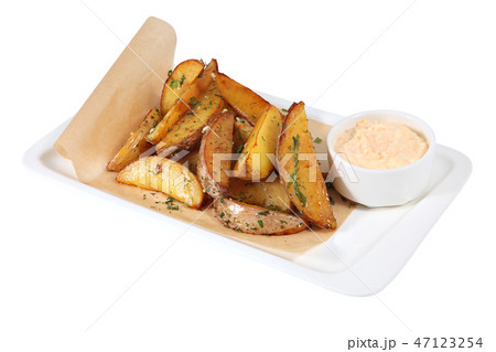 Idaho roasted potato wedges  with sauce on white 47123254