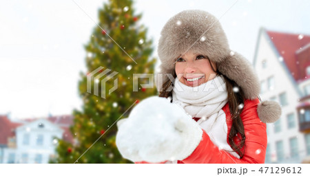 woman with snow over christmas tree at tallinn 47129612