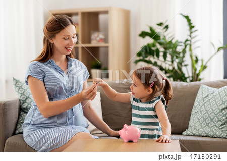 pregnant mother and daughter with piggy bank pregnant mother and daughter with piggy bank 47130291