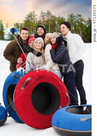 friends with snow tubes taking selfie in winter friends with snow tubes taking selfie in winter 47130373