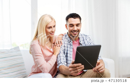 happy couple with tablet computer at home 47130518