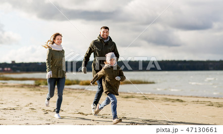 happy family running along autumn beach happy family running along autumn beach 47130661