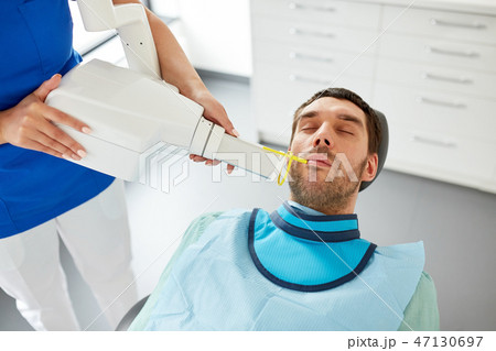 dentist making dental x-ray of patient teeth dentist making dental x-ray of patient teeth 47130697