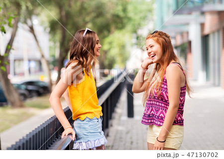 teenage girls or friends talking in summer city 47130702