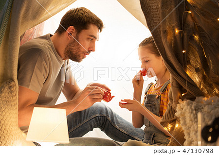 family playing tea party in kids tent at home 47130798