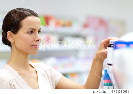 female customer choosing drugs at pharmacy female customer choosing drugs at pharmacy 47131095