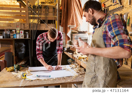 carpenters with ruler and blueprint at workshop 47131164