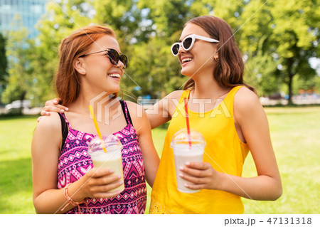 teenage girls with milk shakes at summer park teenage girls with milk shakes at summer park 47131318