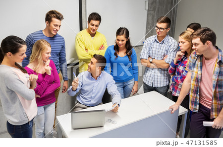 students and teacher with papers and laptop students and teacher with papers and laptop 47131585