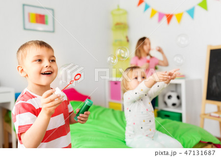 happy children blowing soap bubbles at home 47131687